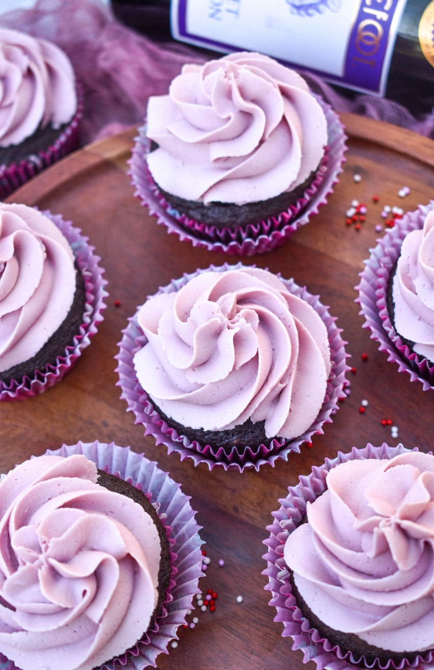 dark chocolate cupcakes with red wine buttercream frosting on a wooden cake stand