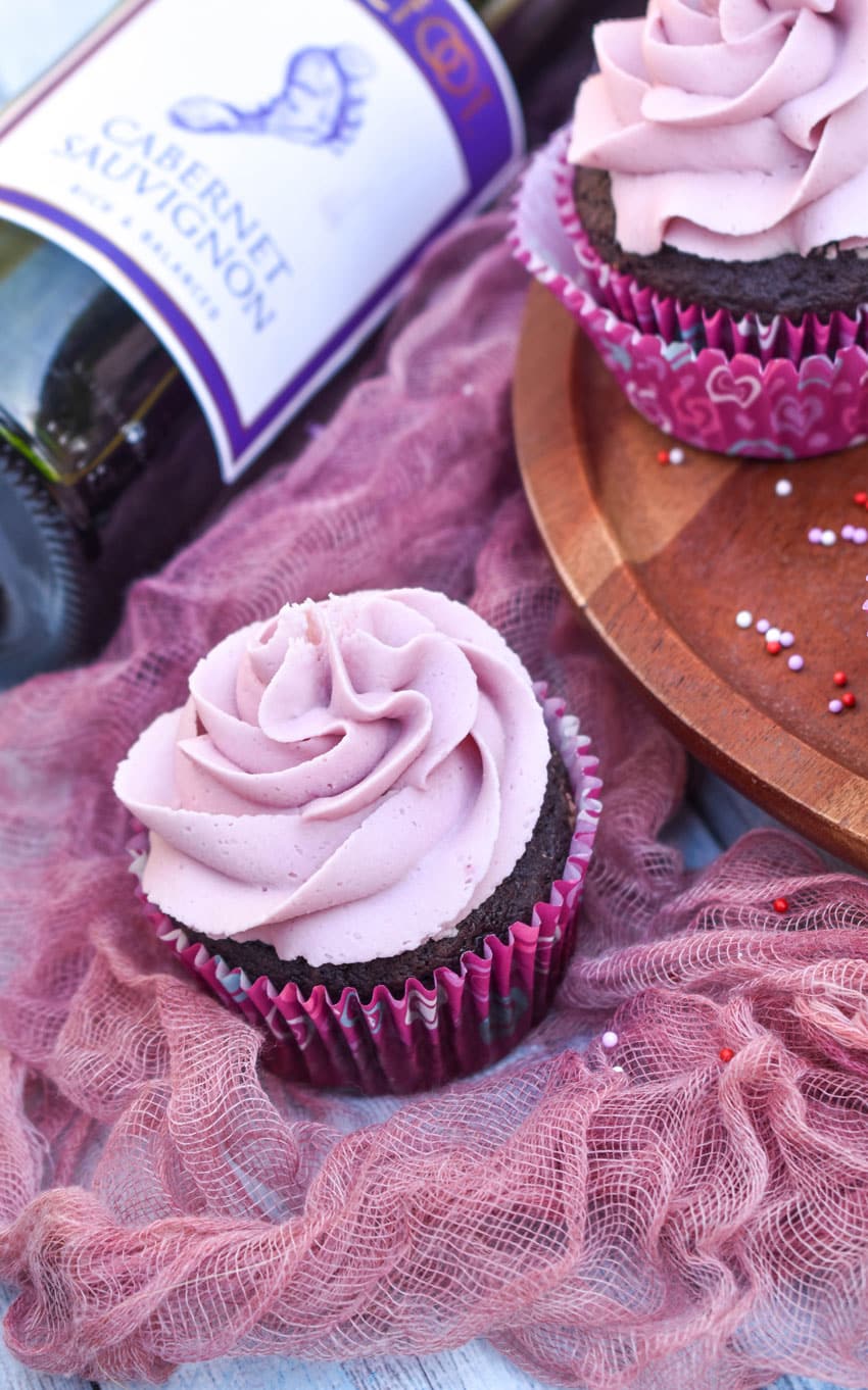 dark chocolate cupcakes with red wine buttercream frosting on a wooden cake stand