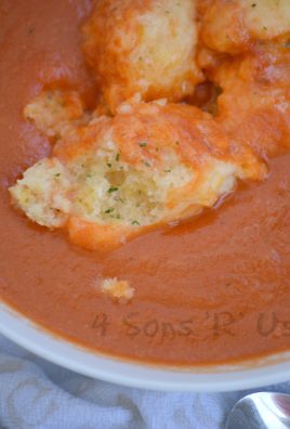 tomato bisque topped with cheddar bay dumplings in a white soup bowl