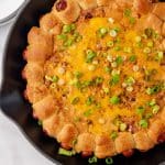 a chili cheese dog dip ring in a black cast iron skillet