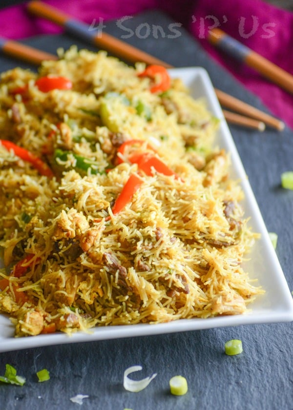 Singapore Rice Noodle shown on a white rectangular platter on a slate cutting board with wooden chop sticks