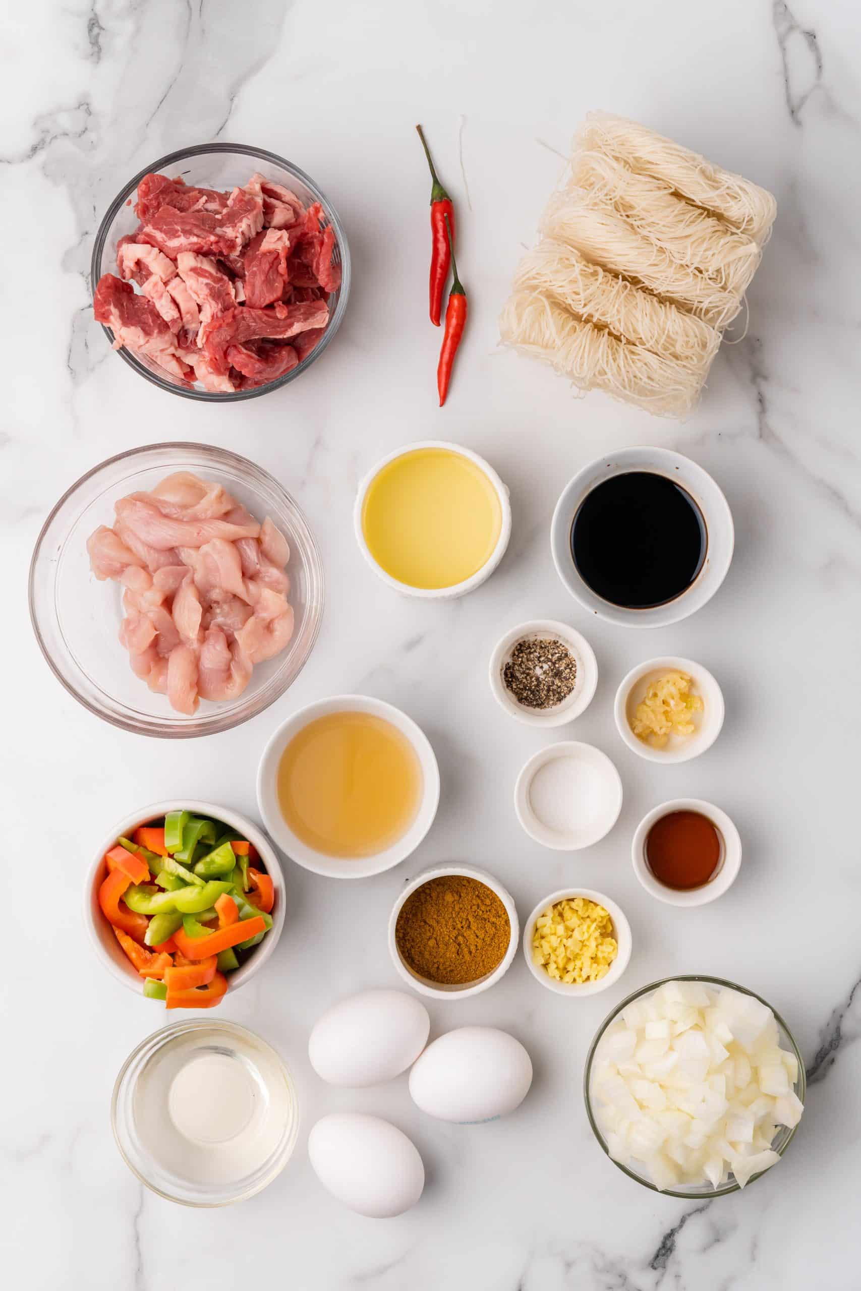 an overhead image showing the measured ingredients needed to make a batch of singapore rice noodle