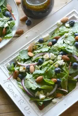 blueberry spinach salad with lemon poppyseed vinaigrette on a white serving platter