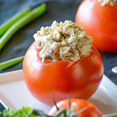 a chicken bacon ranch stuffed tomato on a small white appetizer plate