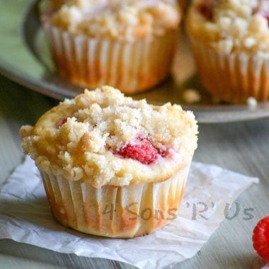 a raspberry lemon yogurt muffin on a small square of white parchment paper