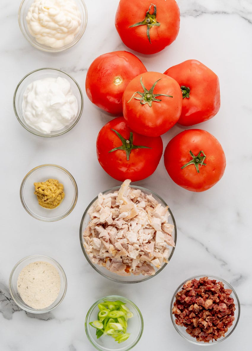 an overhead image showing the measured ingredients needed to make a batch of chicken bacon ranch stuffed tomatoes