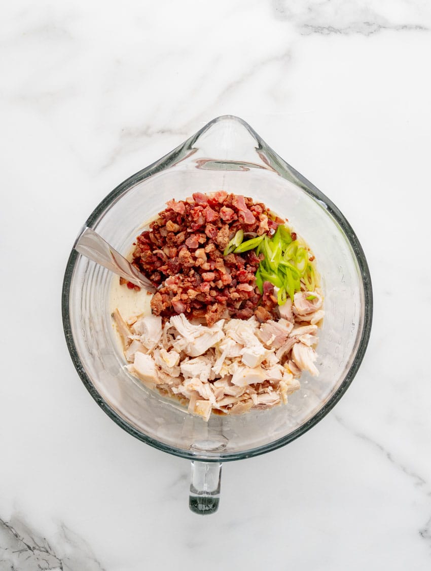 bacon ranch chicken salad ingredients in a glass mixing bowl