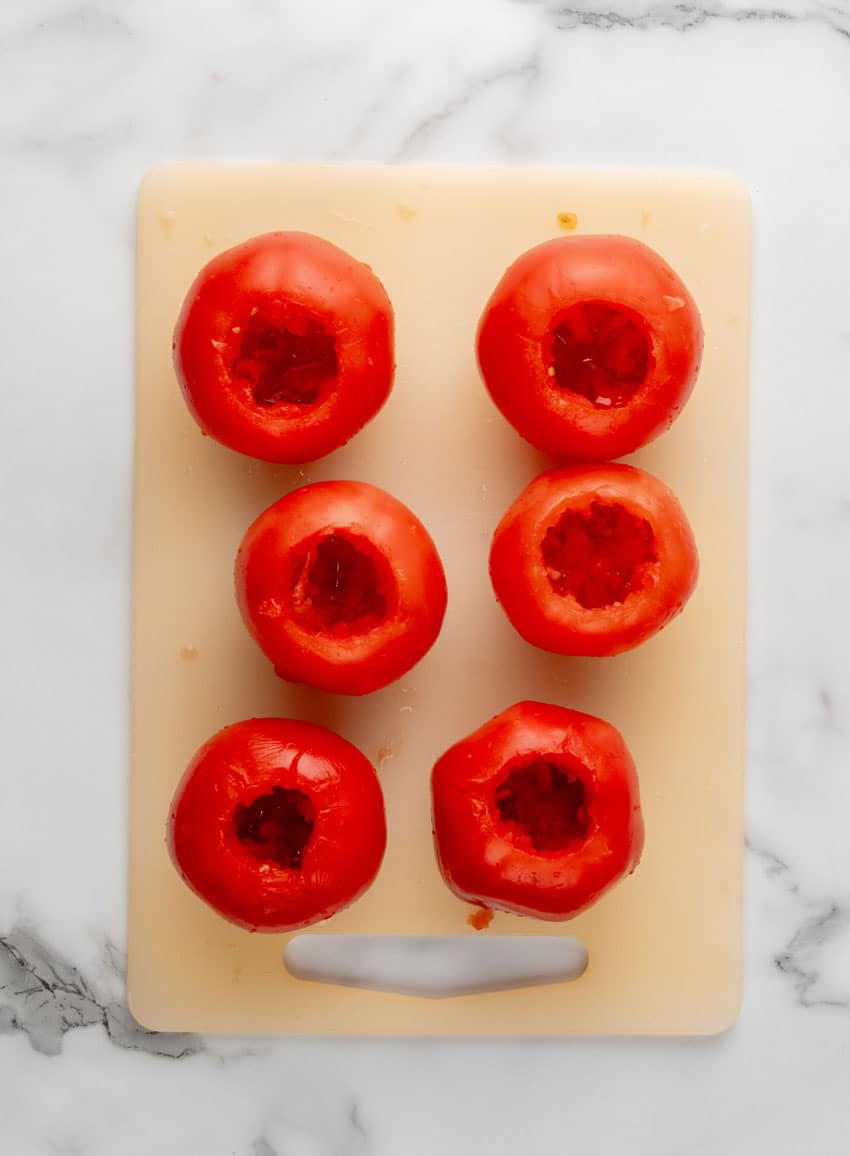 hollowed out vine ripened tomatoes on a plastic cutting board