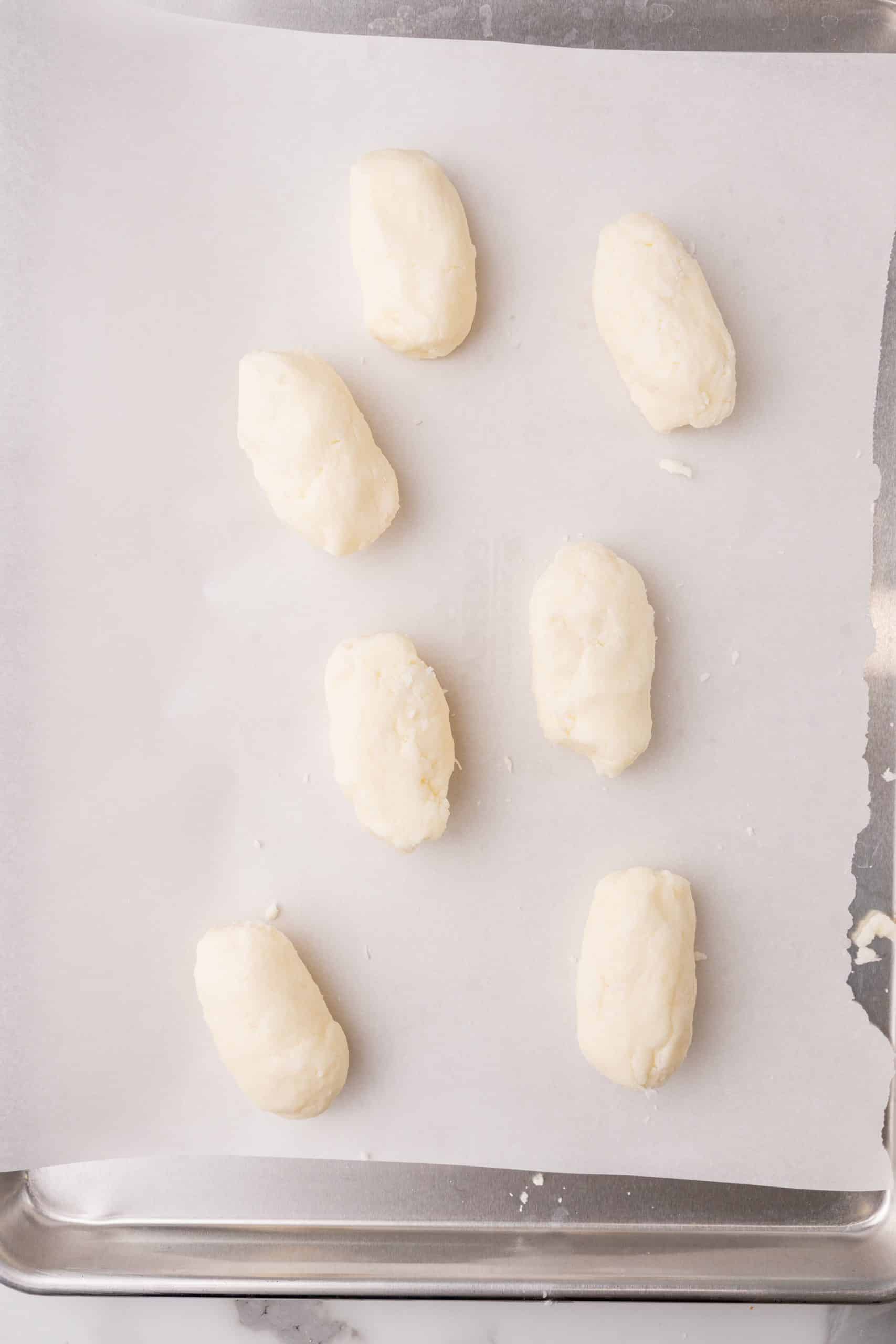 coconut candies on a parchment paper lined baking sheet