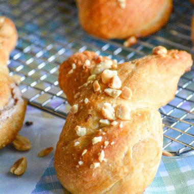 strawberry cream cheese stuffed bunny buns topped with chopped nuts and laid out on a wire cooling rack