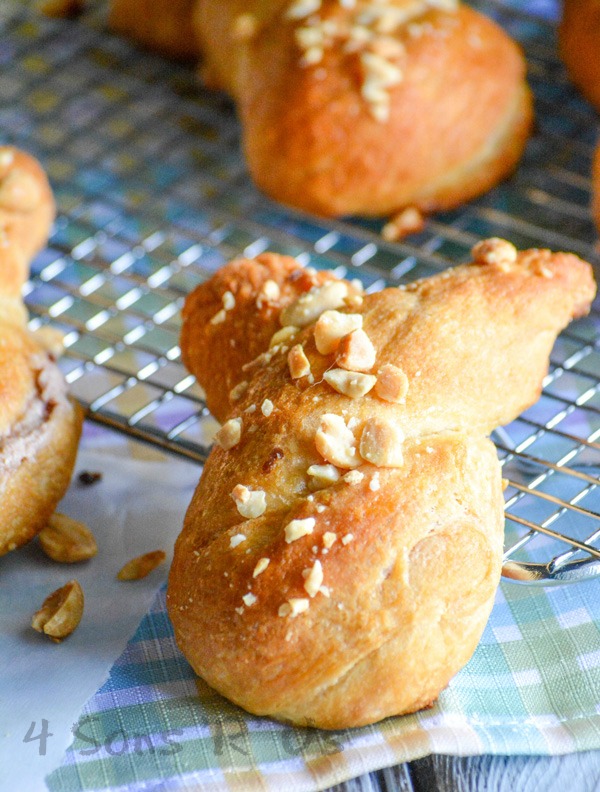 strawberry cream cheese stuffed bunny buns topped with chopped nuts and laid out on a wire cooling rack