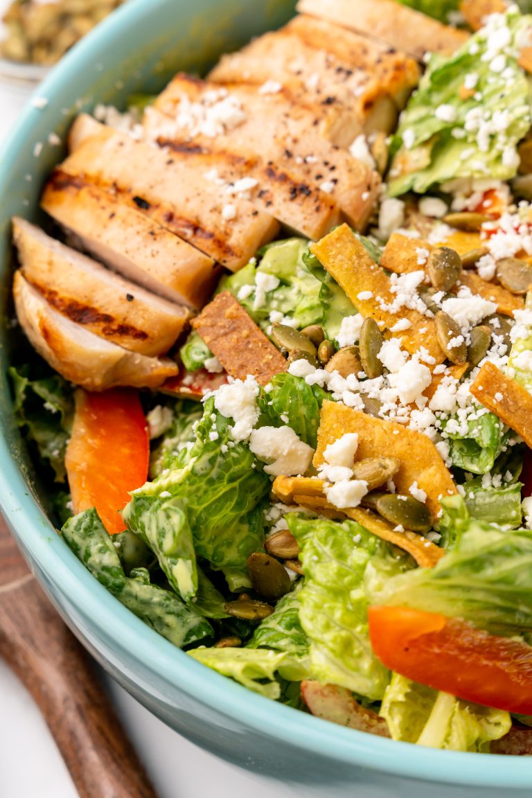 Mexican chicken caesar salad in a shallow blue bowl