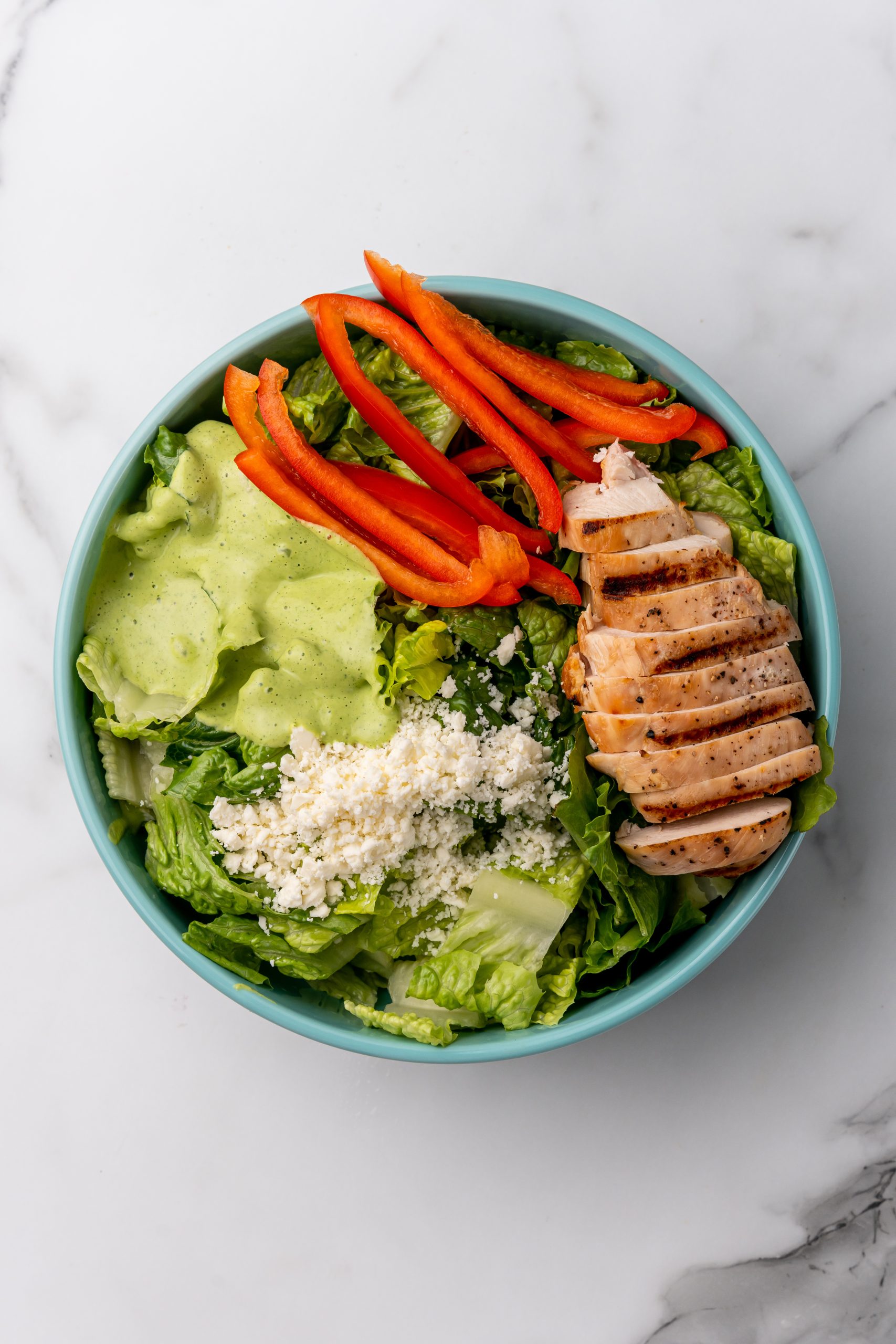 Mexican caesar salad ingredients in a shallow blue bowl