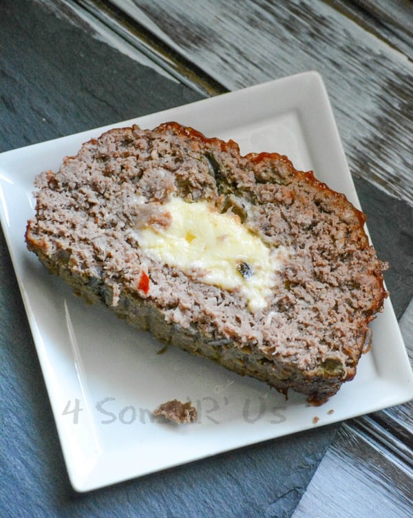 a single slice of All Jack'd Up Stuffed Smoked Meatloaf served on a small white square plate