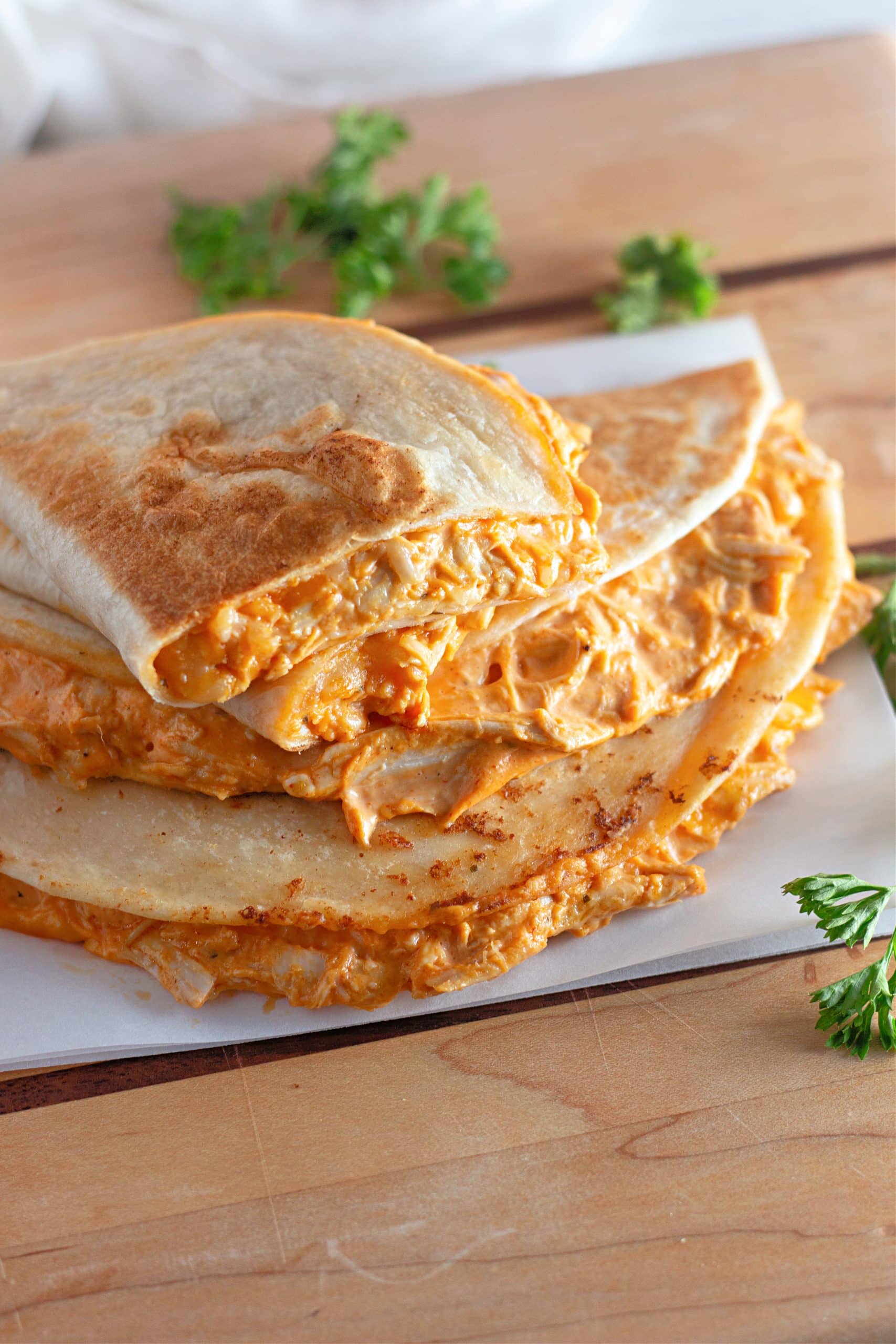 a stack of creamy buffalo chicken quesadillas on a wooden table