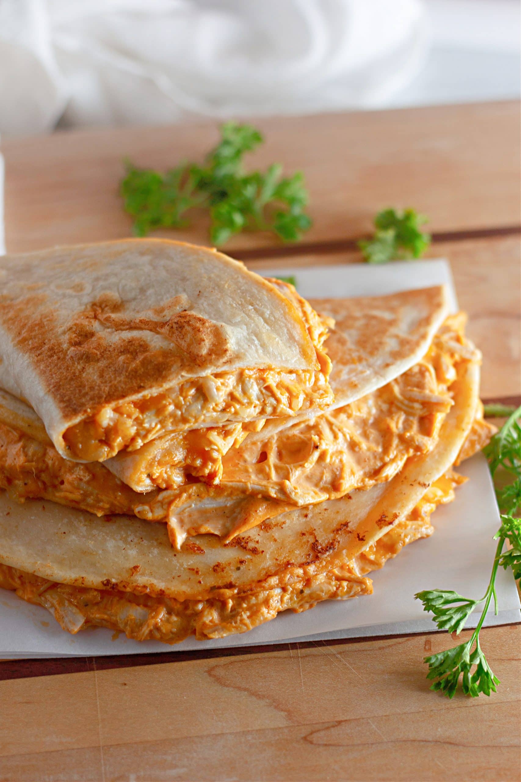 a stack of creamy buffalo chicken quesadillas on a wooden table