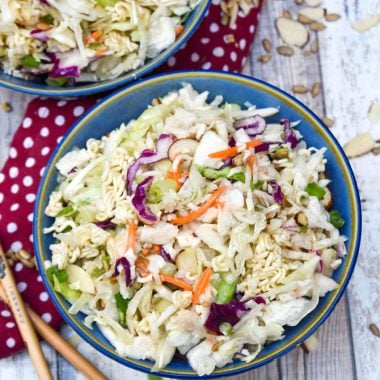 chopped Asian chicken salad with dressing in two blue bowls