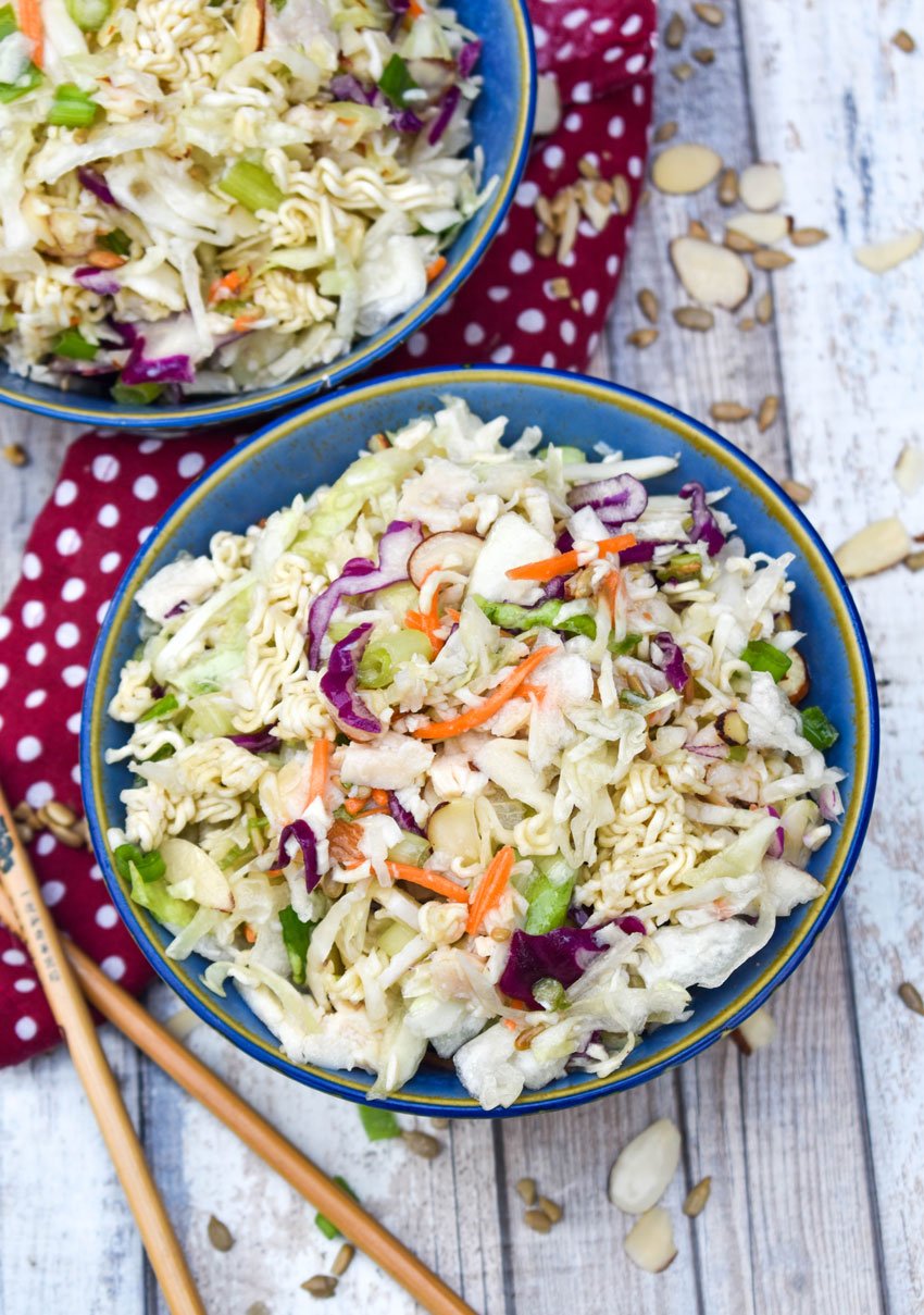 chopped Asian chicken salad with dressing in two blue bowls