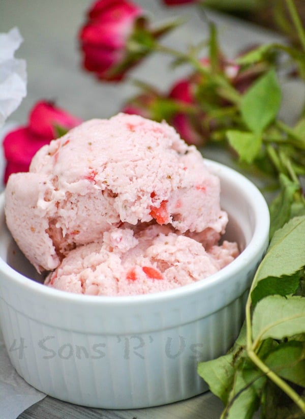 SCOOPS OF STRAWBERRY ROSE ICE CREAM IN A SMALL WHITE RAMEKIN WITH PINK ROSES IN THE BACKGROUND