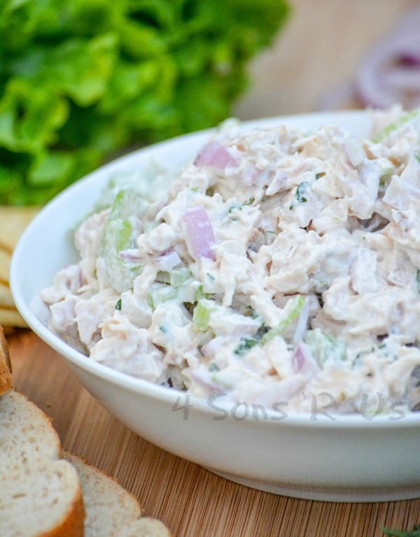 lemon tarragon chopped chicken salad served in a white bowl on a wooden cutting board