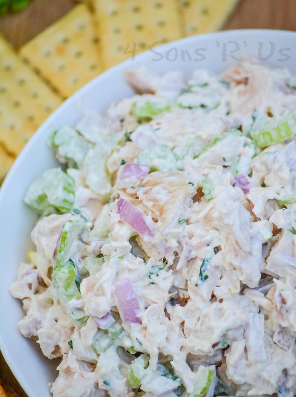 lemon tarragon chopped chicken salad served in a white bowl on a wooden cutting board