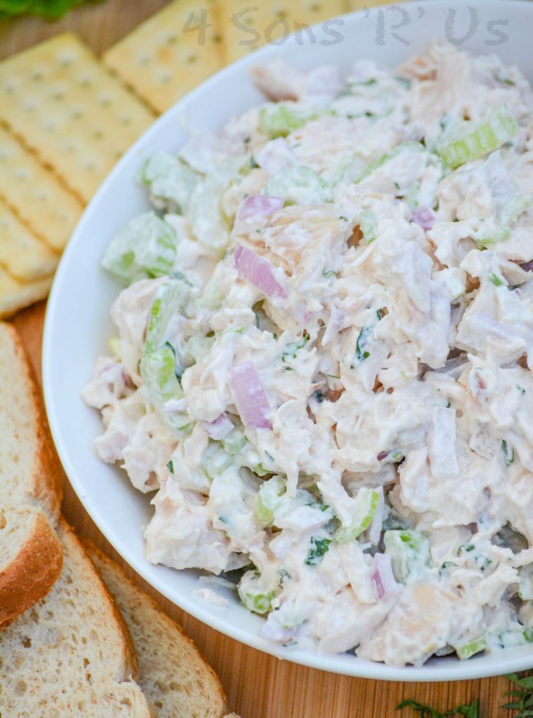 lemon tarragon chopped chicken salad served in a white bowl on a wooden cutting board