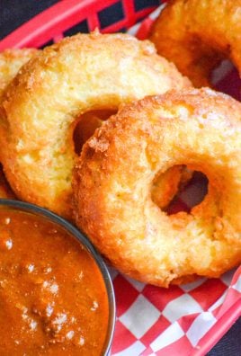 macaroni and cheese donuts in a paper lined plastic food basket with a side of chili for dipping