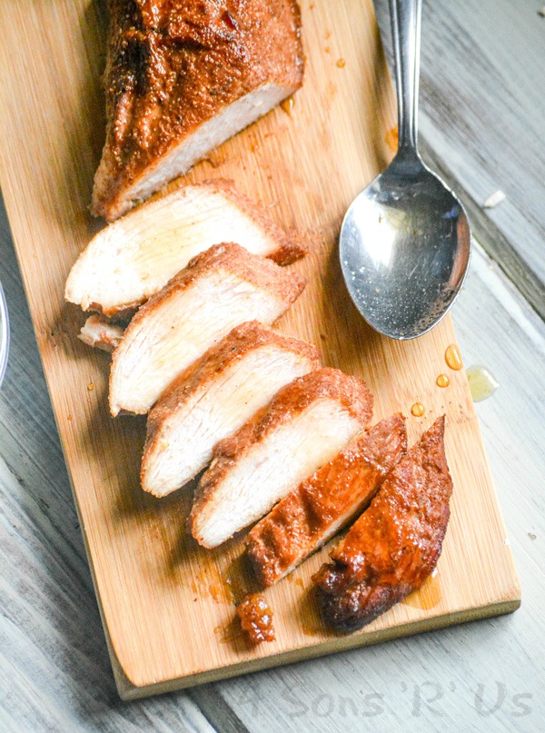 A SLICED MAPLE CHIPOTLE SMOKED CHICKEN BREAST ON A WOODEN SERVING BOARD