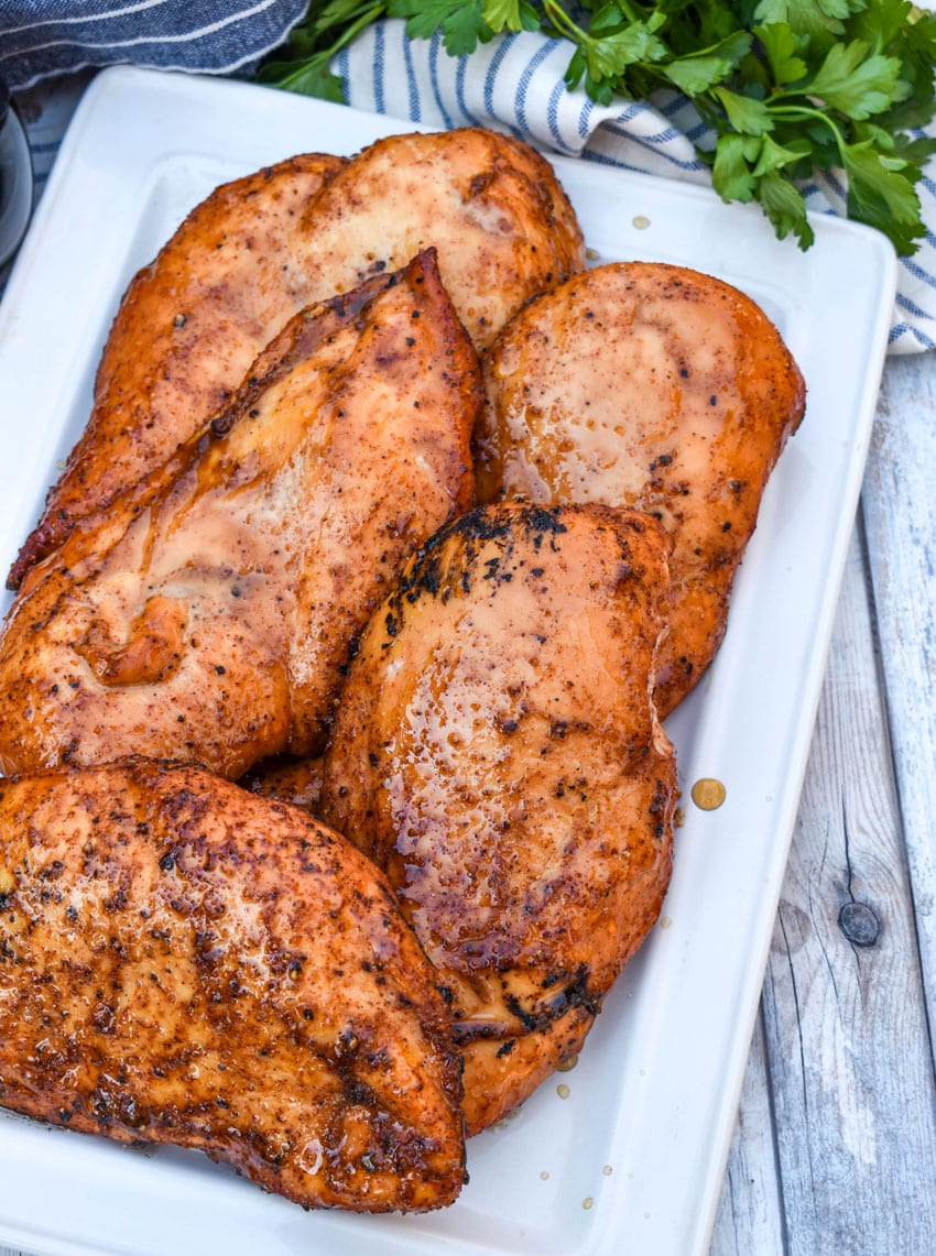 maple chipotle smoked chicken breasts on a white serving platter