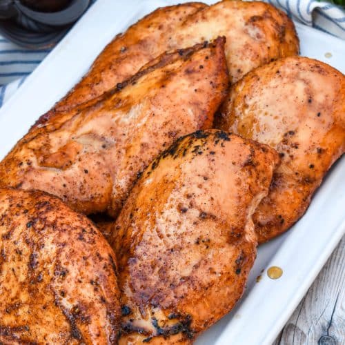 maple chipotle smoked chicken breasts on a white serving platter