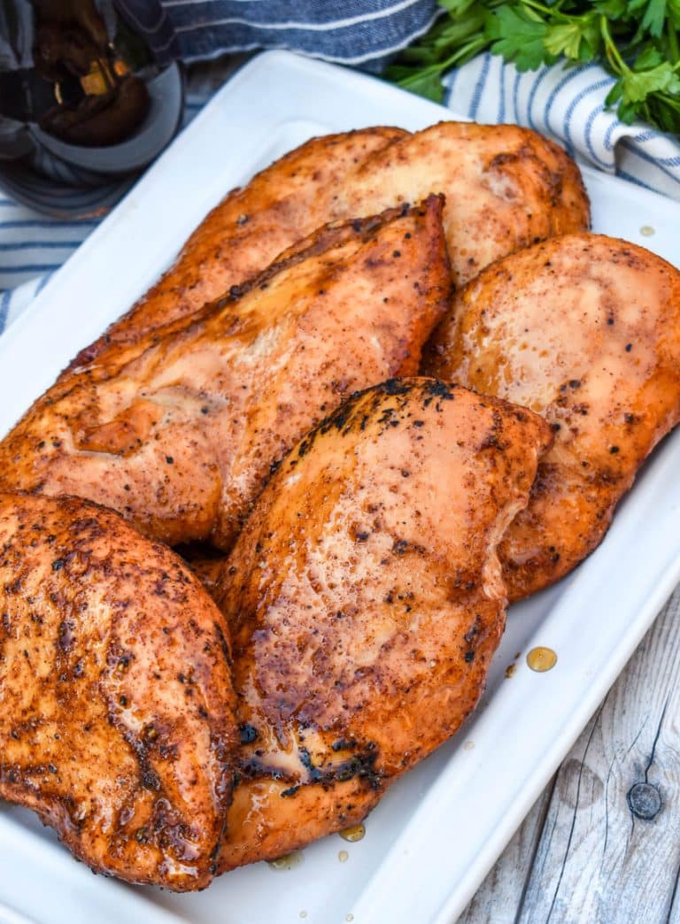maple chipotle smoked chicken breasts on a white serving platter