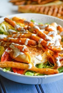french fry topped pittsburgh salad with chicken in a white bowl
