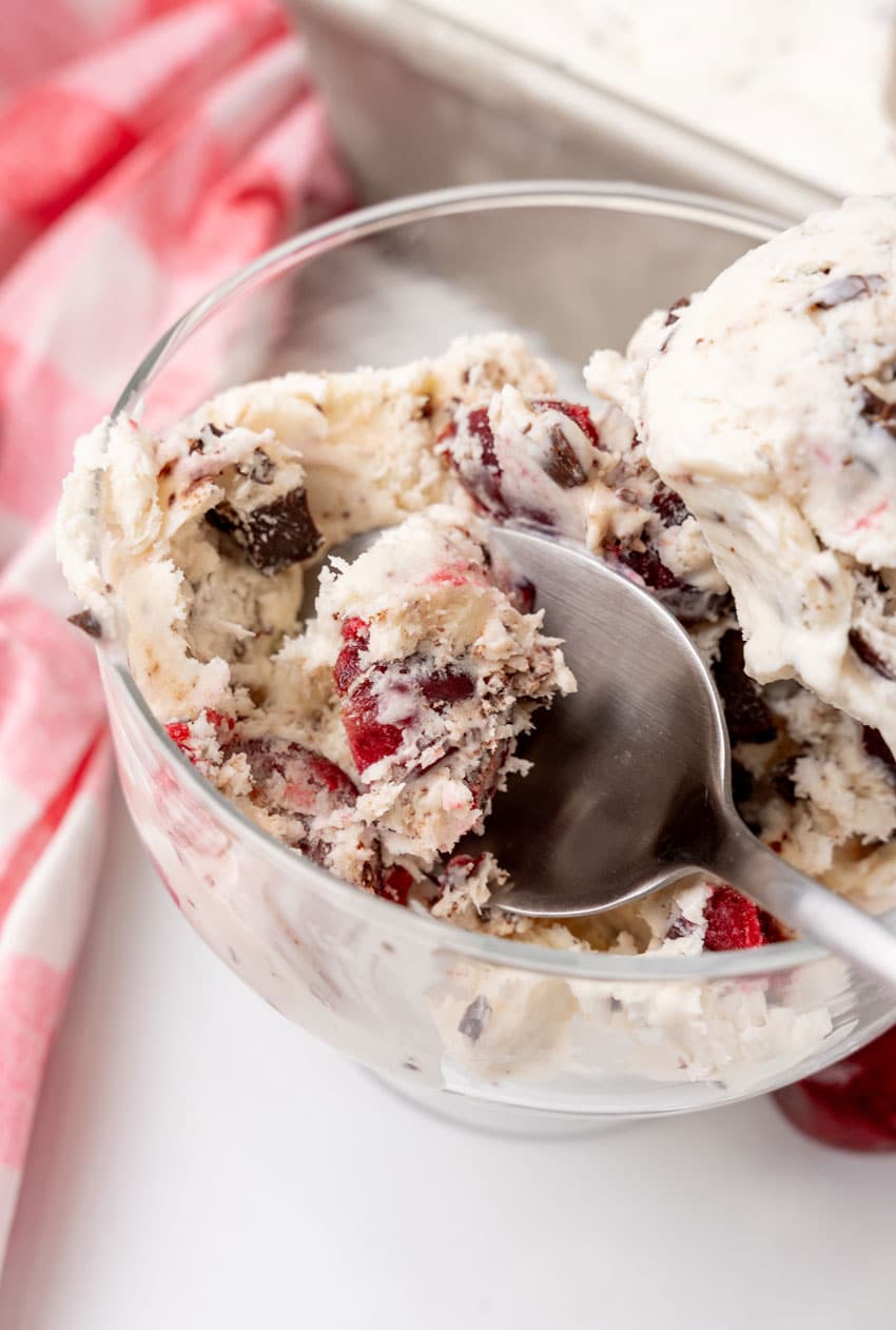 a silver spoon scooping homemade ben and jerry's ice cream out of a small glass dish