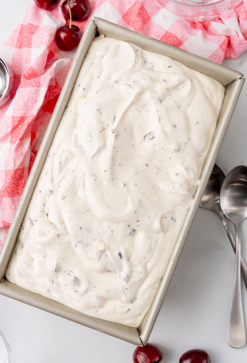 no churn cherry chocolate ice cream mixture in a metal loaf pan