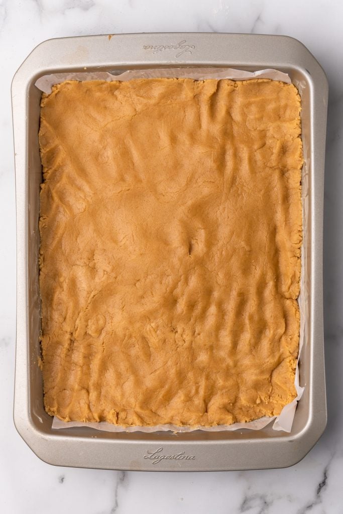 peanut butter batter spread in a large baking pan
