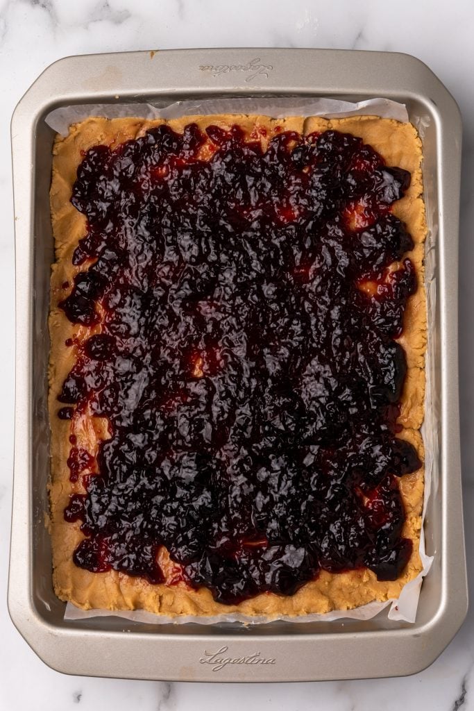 grape jelly spread over peanut butter batter in a large baking pan