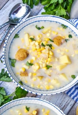 corn off the cobb soup in white bowl topped with fresh chopped green herbs