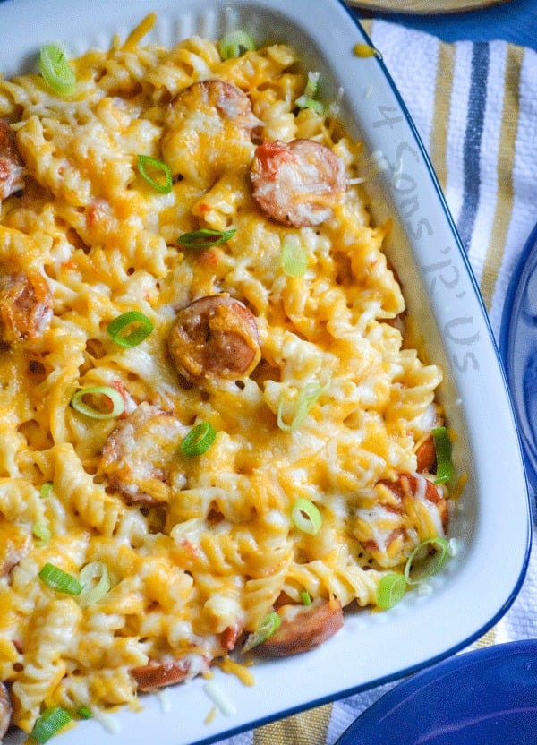 Spicy Sausage and Pasta Casserole is in a white ceramic casserole dish on a striped background