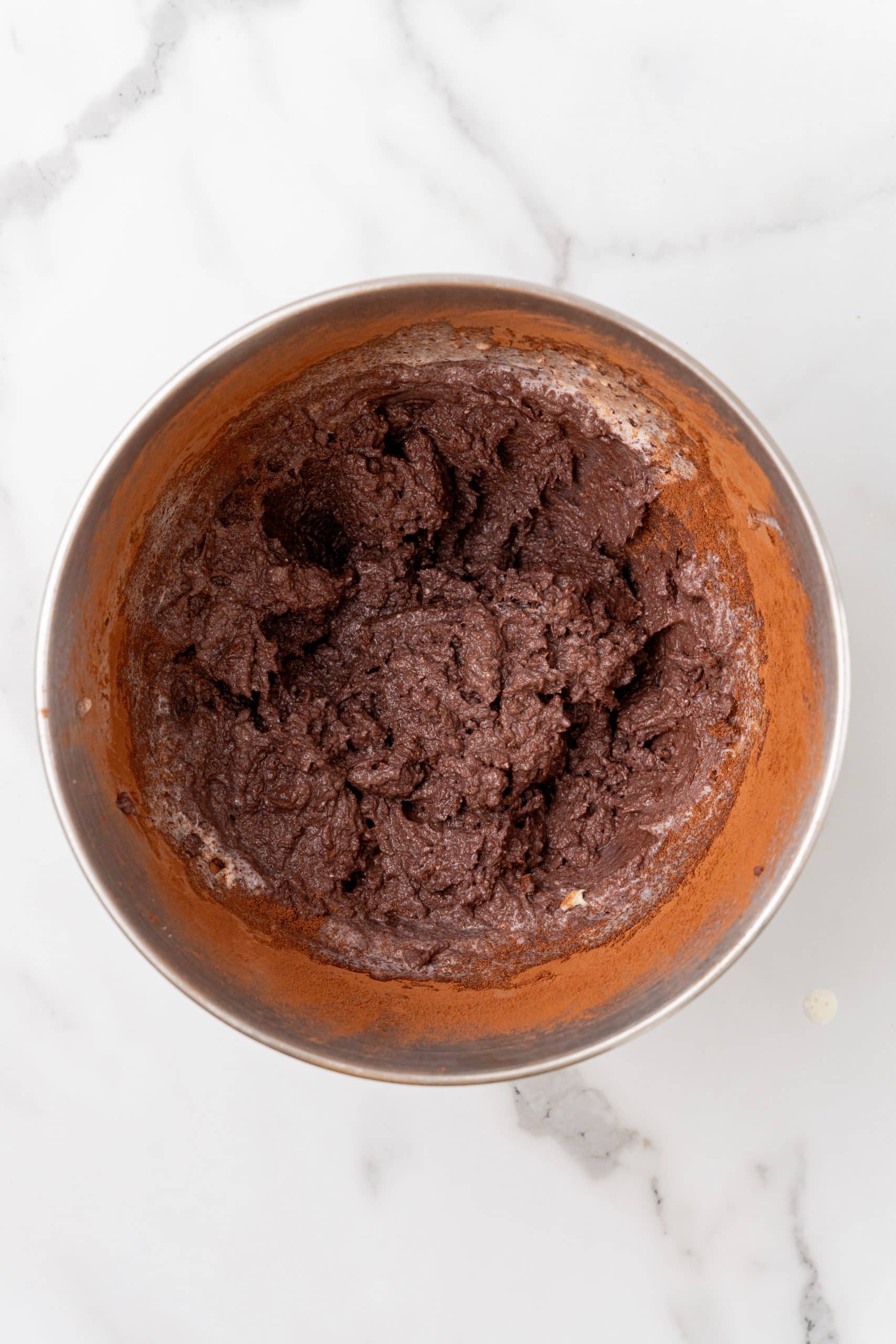 chocolate malt frosting in a metal mixing bowl