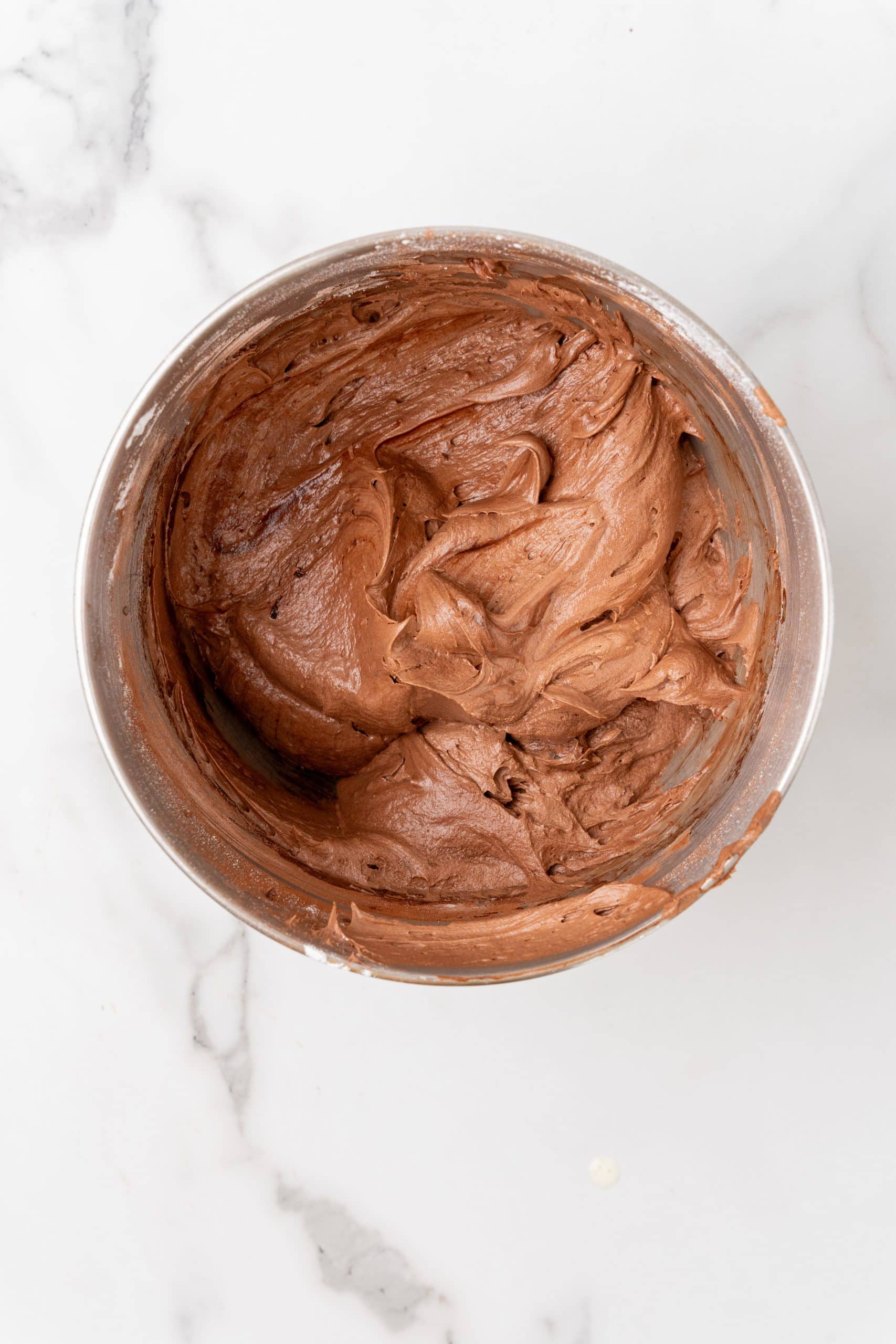 chocolate malt butter cream frosting in a metal mixing bowl