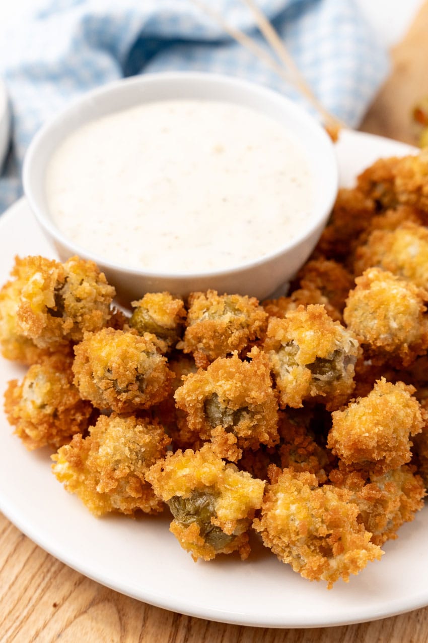 fried olives with a bowl of garlic aioli on a white plate