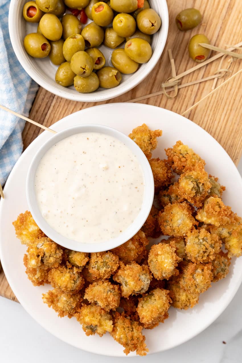 fried olives with a bowl of garlic aioli on a white plate