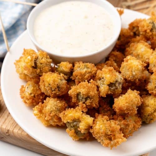 fried olives with a bowl of garlic aioli on a white plate