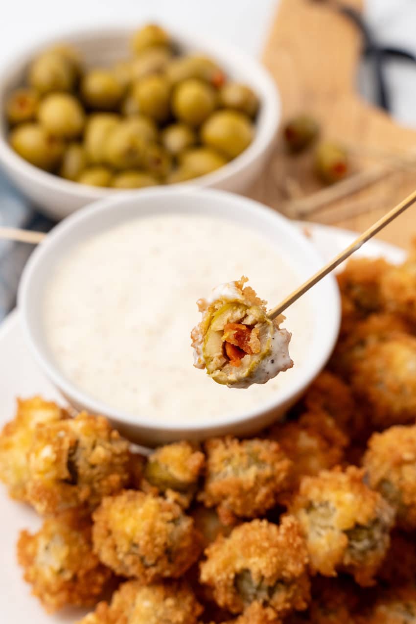 a halved fried olive on the end of a wooden toothpick