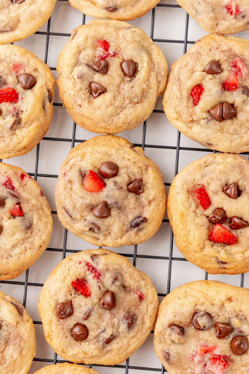 a close up of strawberry chocolate chip cookies on a wire rack