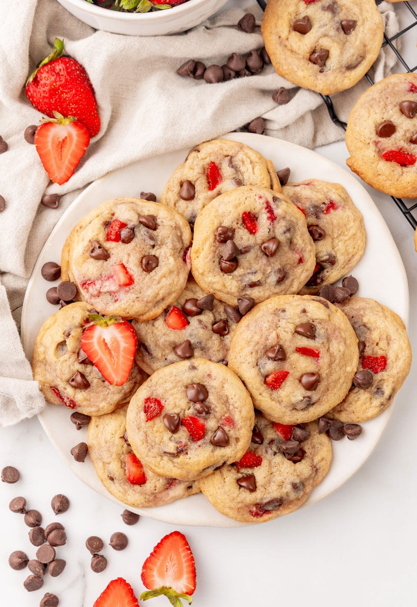 a pile of strawberry chocolate chip cookies on a white serving plate