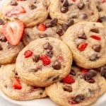 a pile of strawberry chocolate chip cookies on a white serving plate