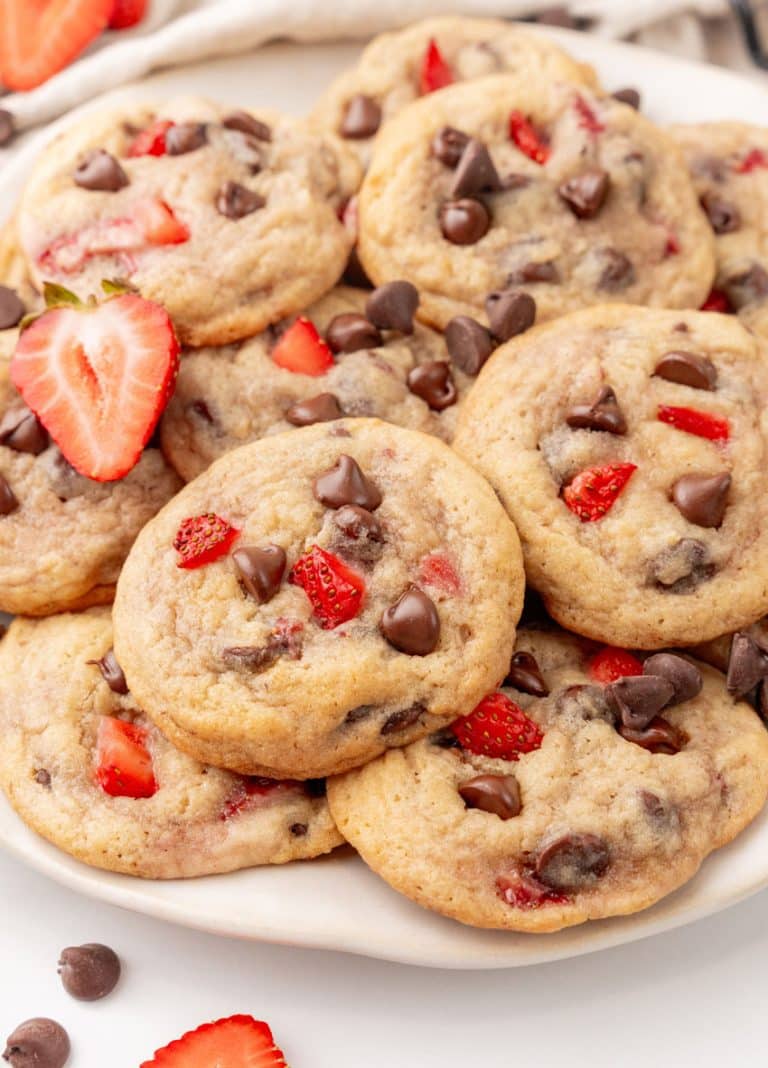 a pile of strawberry chocolate chip cookies on a white serving plate