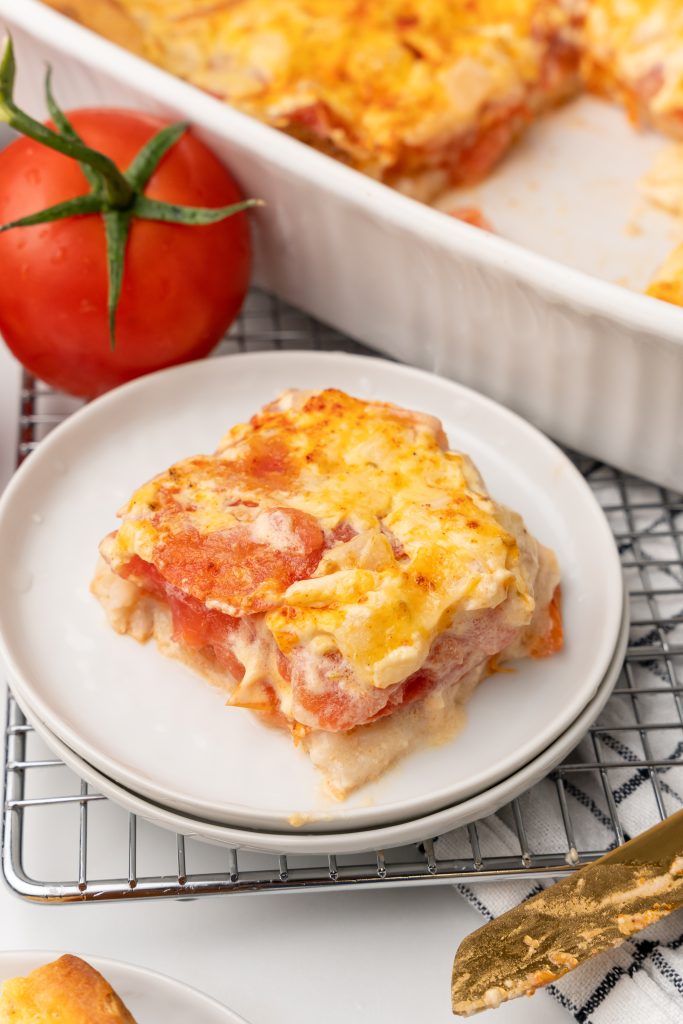 a slice of cheesy tomato biscuit casserole on a small white plate