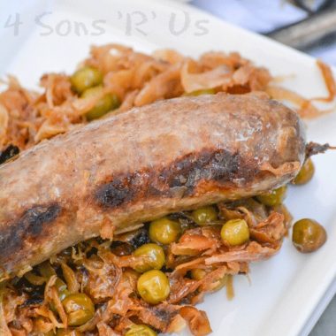 seared beer bratwurst over a bed of caramelized sauerkraut on a white plate